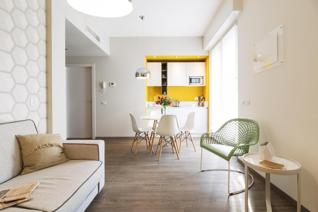 un soggiorno con divano, tavolo e sedie di Contempora Apartments - Cavallotti 13 - A63 a Milano
