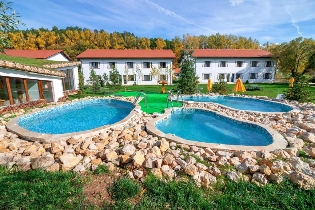 a backyard with two pools and a rock wall at Wolkendorf Bio Hotel & Spa in Vulcan