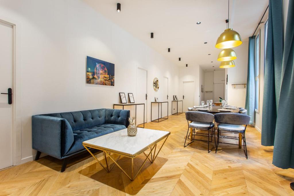 ein Wohnzimmer mit einem Sofa und einem Tisch in der Unterkunft CMG-Champs Elysées - Boetie 8 in Paris