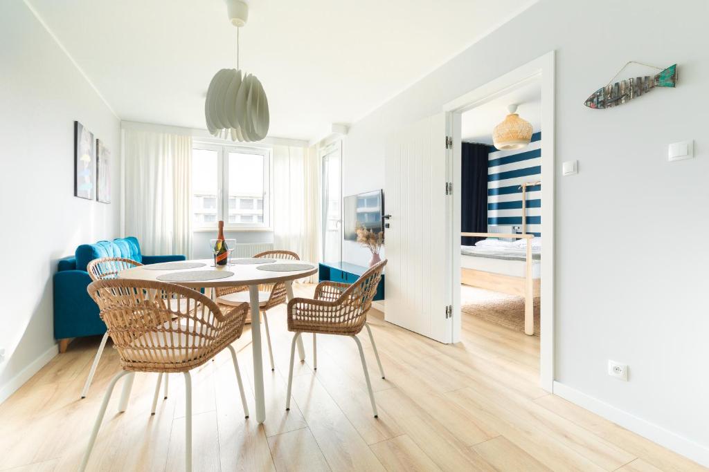 Chill and Sun في كولوبرزيغ: غرفة طعام وغرفة معيشة مع طاولة وكراسي