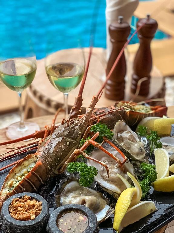a plate of seafood with two glasses of wine at Aurico Kata Resort & Spa - SHA Extra Plus in Kata Beach