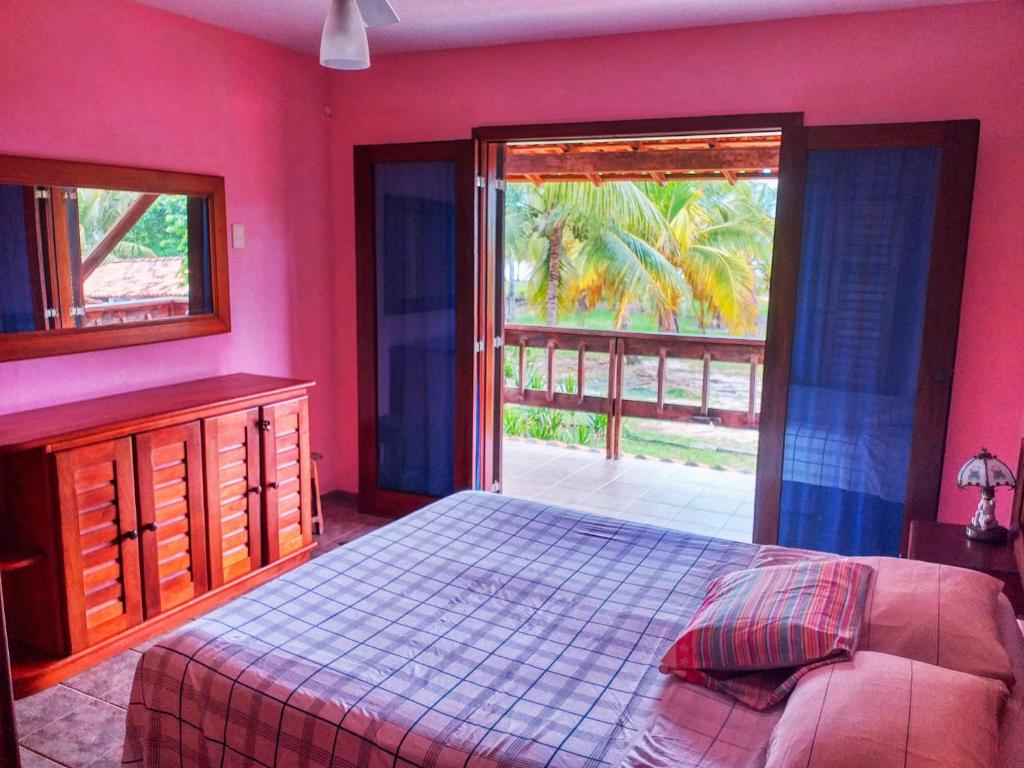 1 dormitorio con paredes rosas, 1 cama y ventana en Feriasmares, en Ilhéus