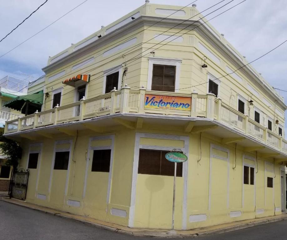un edificio amarillo con balcón en la parte superior en Hotel Victoriano, en San Felipe de Puerto Plata