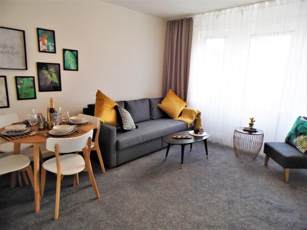 a living room with a couch and a table at Trident Apartment in Paisley