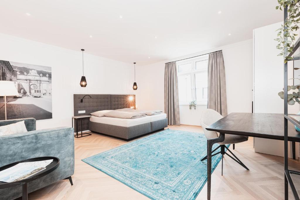 1 dormitorio con cama, mesa y sofá en Top Center-Apartment - Wohnung im Stadtzentrum in perfekter Lage & Balkon, en Innsbruck
