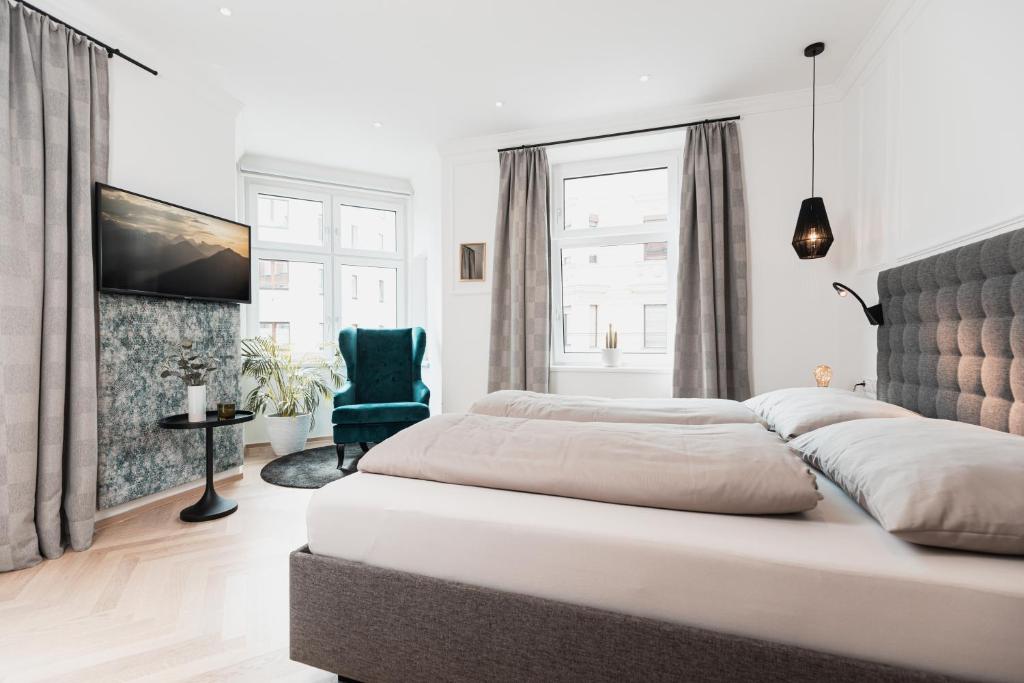 1 dormitorio con 2 camas y silla azul en Center-Apartment - Große Wohnung im Stadtzentrum in perfekter Lage en Innsbruck