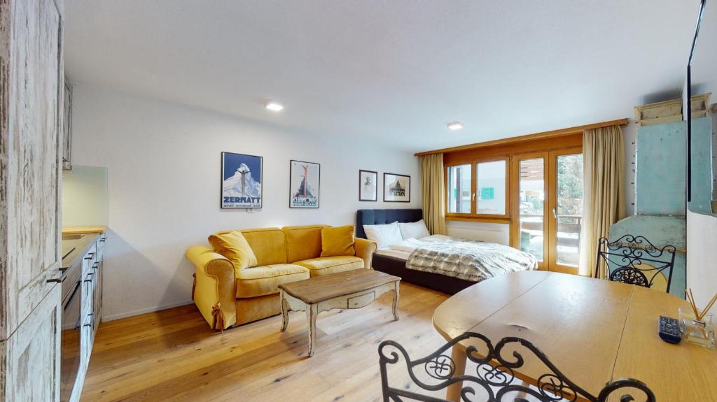 un soggiorno con divano e tavolo di Bright studio with balcony & view to the Matterhorn a Zermatt