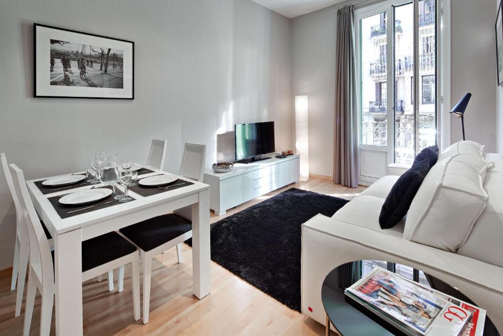 a living room with a white table and a white couch at Habitat Apartments Batlló in Barcelona