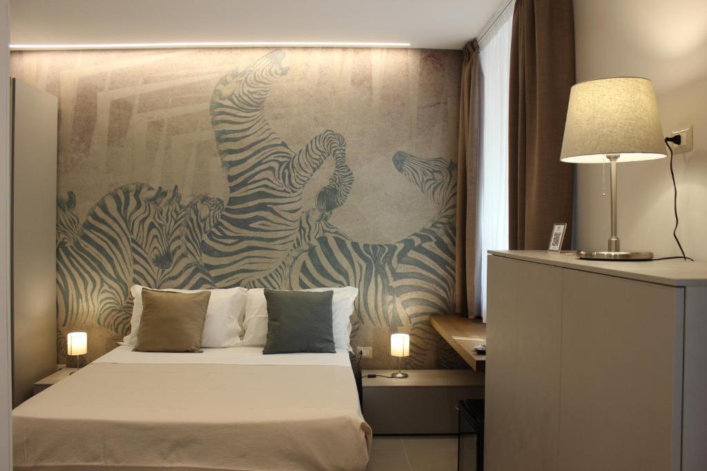een slaapkamer met een bed en een schilderij van zebra's bij BeBIGEA Siracusa in Siracusa