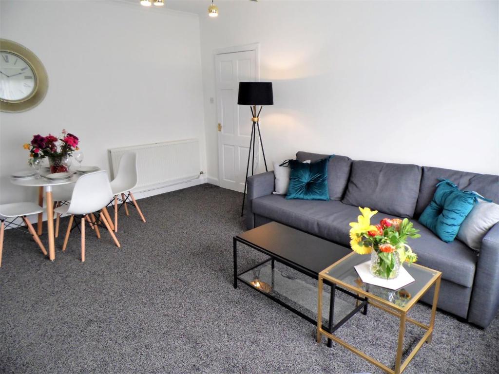 a living room with a couch and a table at Penilee Upper Apartment in Glasgow