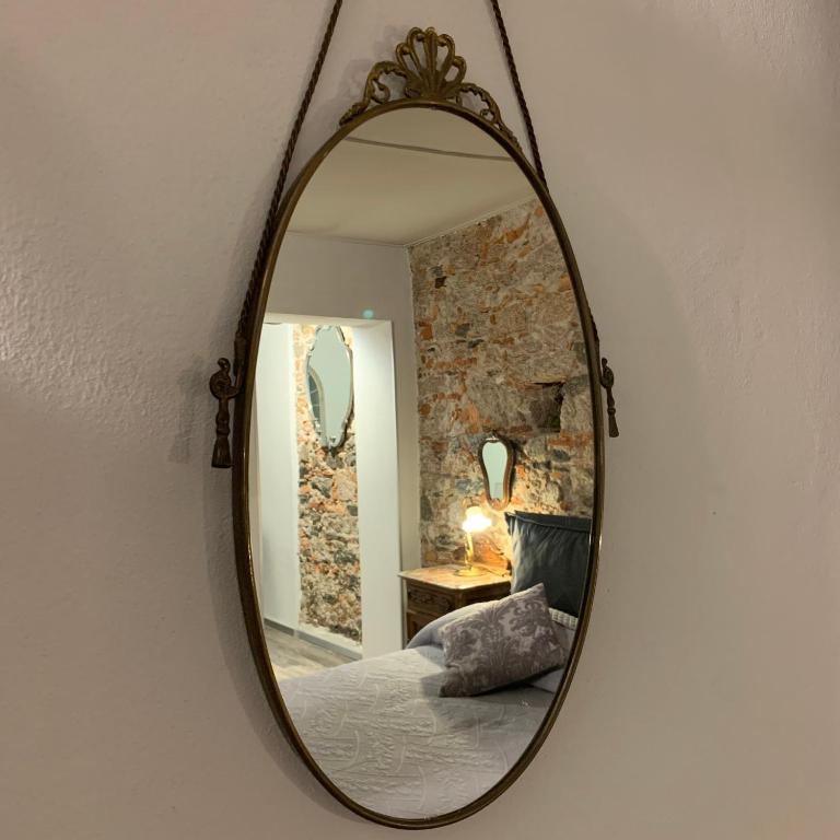 a mirror hanging on a wall in a bedroom at Il Giardino Segreto Arona, Charming Apartments in Arona
