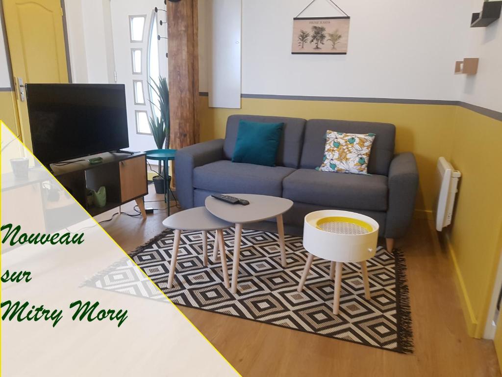 sala de estar con sofá y mesa en F3 l'escale Conviviale - Villepinte Aéroport CDG - Parc Astérix - Paris en Mitry-Mory