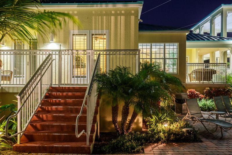 a house with stairs and palm trees in front of it at Grand Marina Suite by Brightwild-Waterfront Condo in Key West