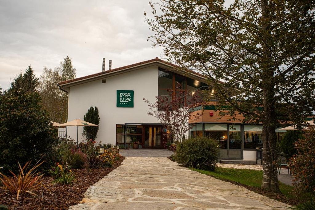 a white building with a green sign on it at Soraluze Hotela in Oñati