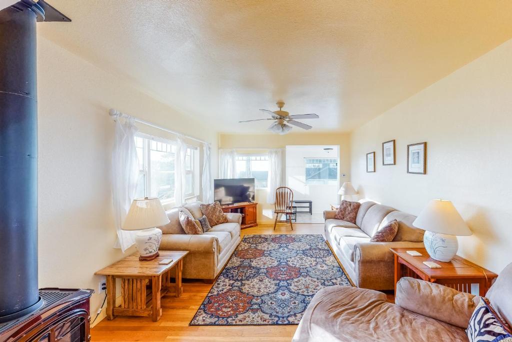 a living room with couches and a tv at Cottage at Nye Beach in Newport