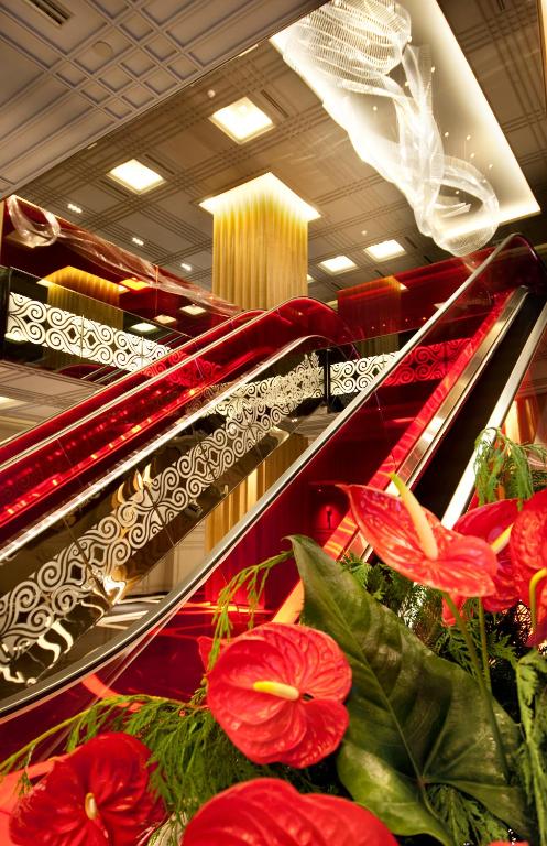an escalator in a store with red flowers on it at The Marmara Taksim in Istanbul