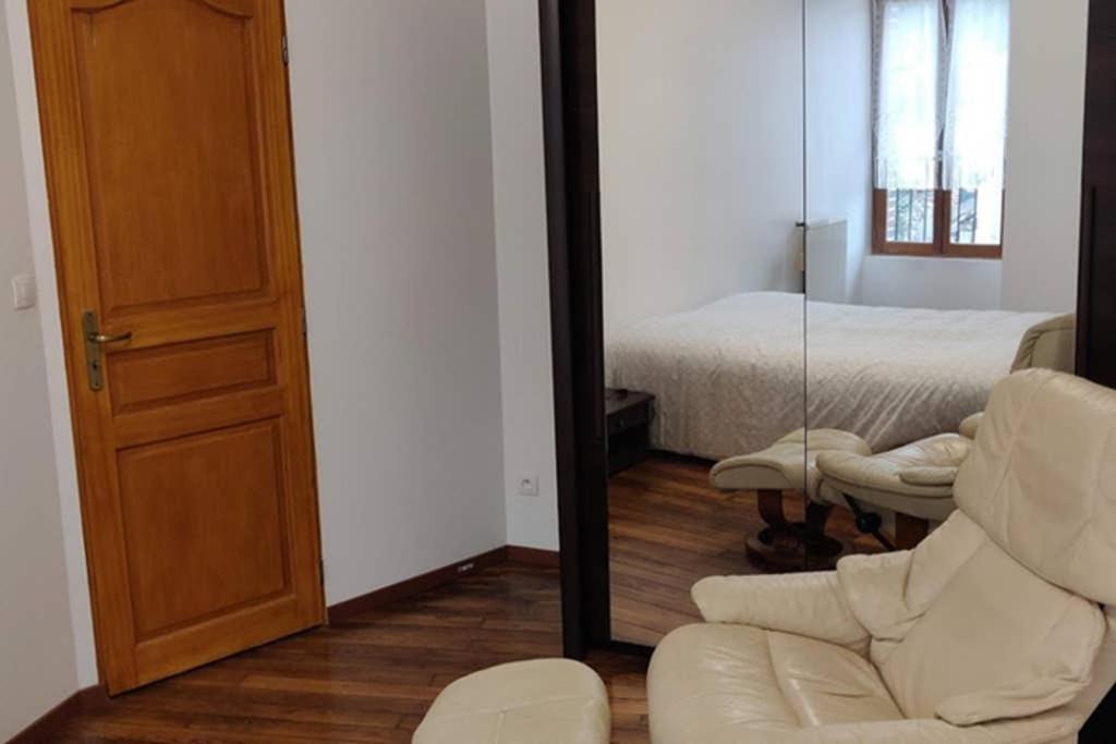 sala de estar con espejo, sofá y cama en le rempart, en Saint-Julien-du-Sault