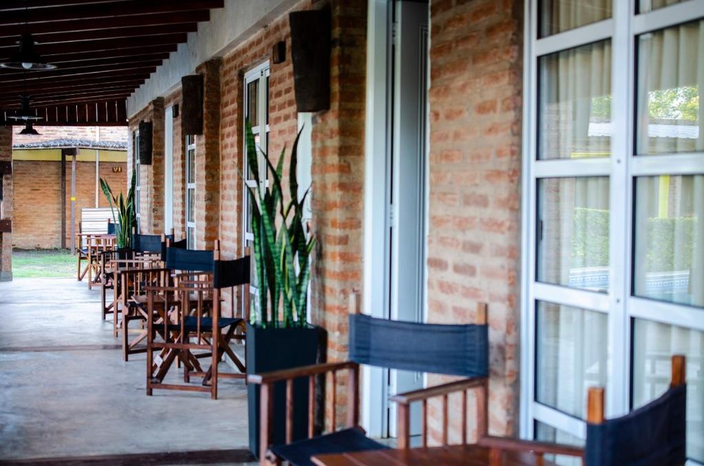 a row of chairs and tables in a room with windows at Cabañas Solar del Paso in Paso de la Patria