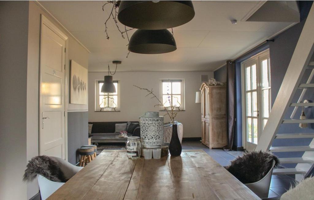 ein Wohnzimmer mit einem Holztisch und einer Treppe in der Unterkunft KoksenCo in Stevensbeek