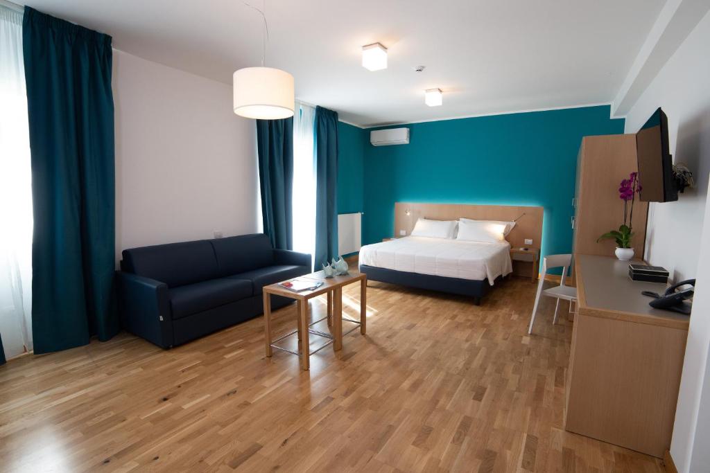 a hotel room with a bed and a couch at Principe Alogna Hotel & SPA in Altavilla Milicia