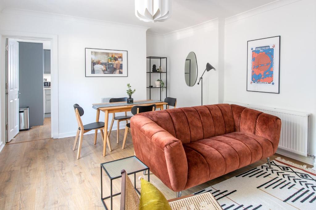 a living room with a brown couch and a table at Stunning Apartment In Peaceful Central Neighbourhood, Free Private Parking in Cardiff