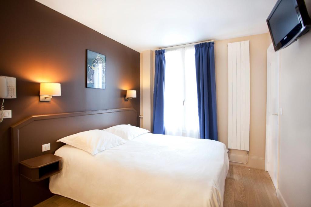 1 dormitorio con cama blanca y ventana en Nadaud Hotel en París