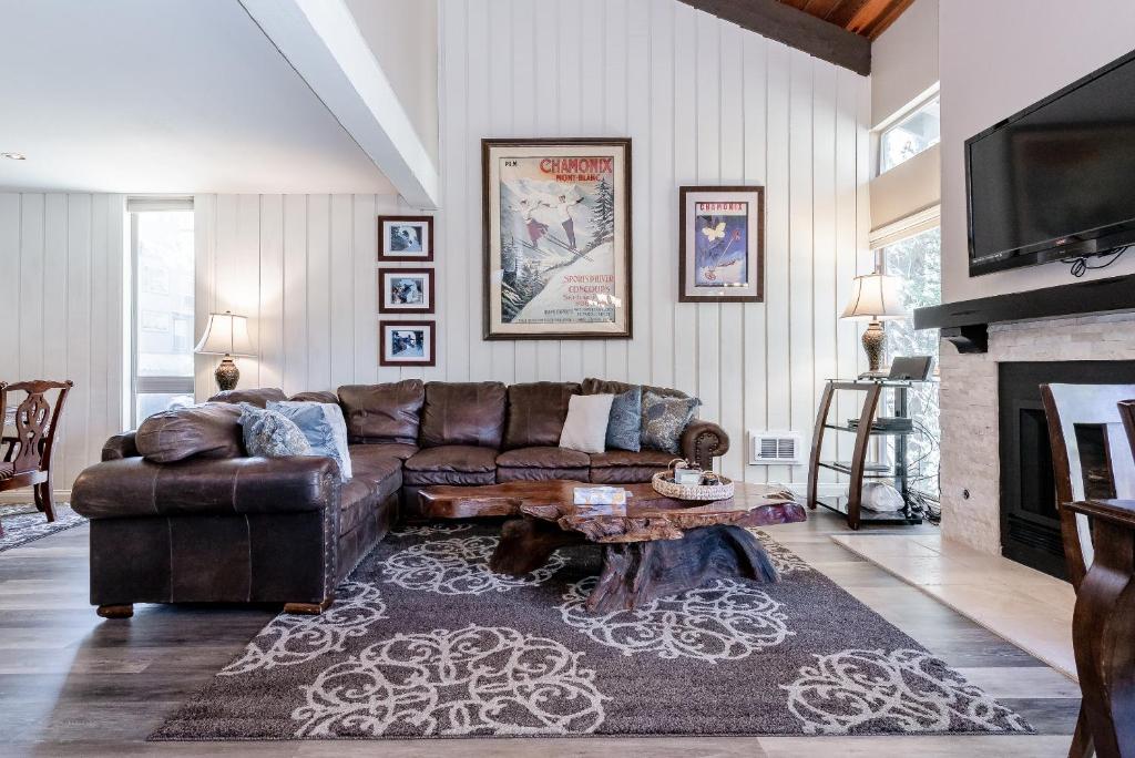 a living room with a leather couch and a fireplace at Chamonix # 88 in Mammoth Lakes