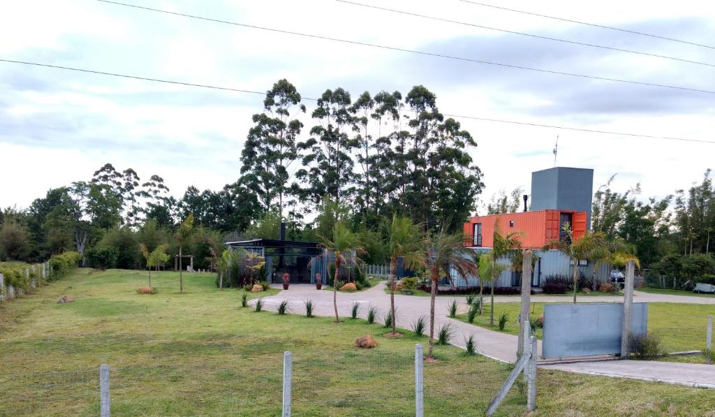 a park in front of a red building at Pousada Casa de Ferro in Passo de Torres