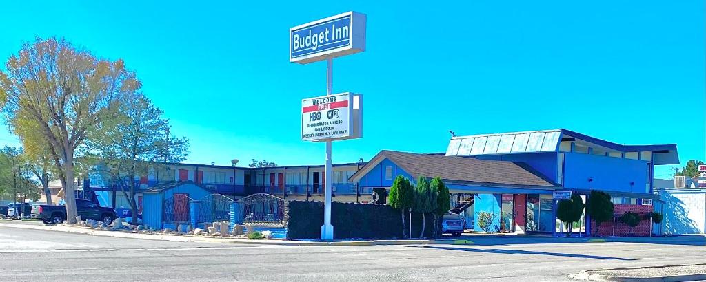 ein Straßenschild vor einem blauen Gebäude in der Unterkunft Budget Inn in Roswell