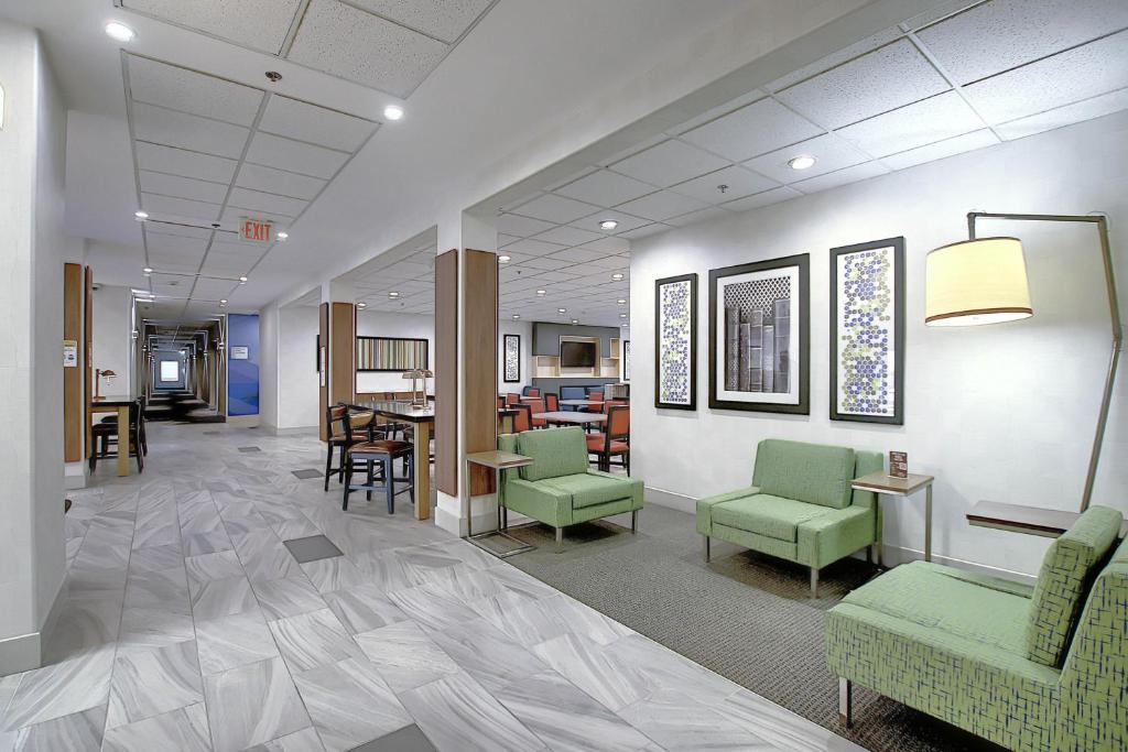 a lobby with green chairs and a table in a building at Holiday Inn Express Airport Calgary, an IHG Hotel in Calgary