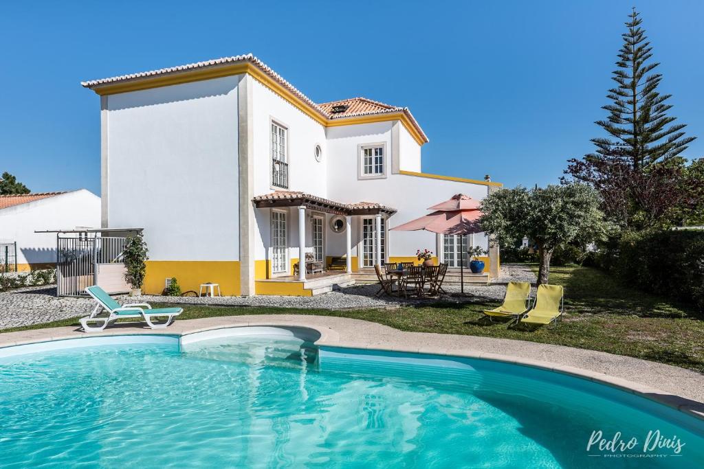 a villa with a swimming pool in front of a house at 4 bedrooms villa with private pool enclosed garden and wifi at Azeitao in Azeitao