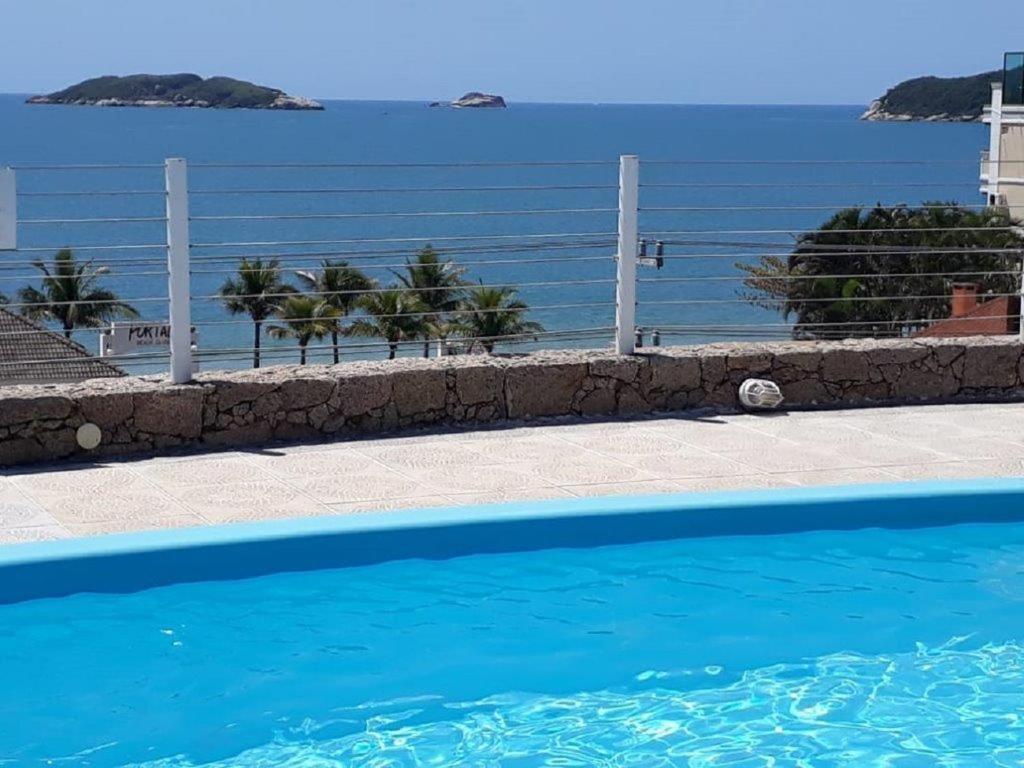 a blue swimming pool with a view of the ocean at Mirante dos Ingleses in Florianópolis