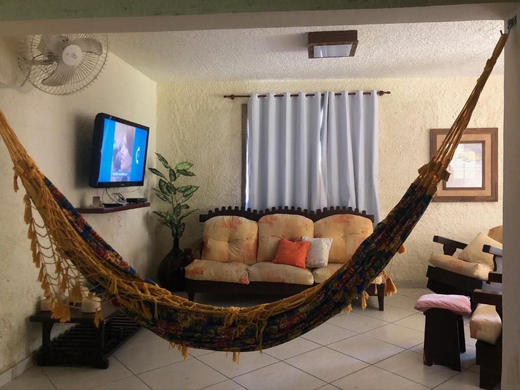 hamaca colgante en una sala de estar con sofá en Casa Confortável - Cabo Frio, en Cabo Frío