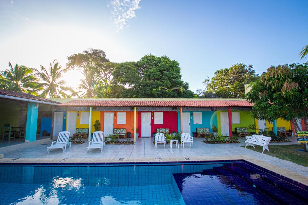una casa con piscina frente a ella en Pousada Vila Nalu en Praia do Frances