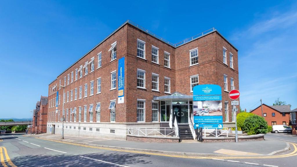 a large brick building with a sign in front of it at Concorde House Luxury Apartments - Chester in Chester