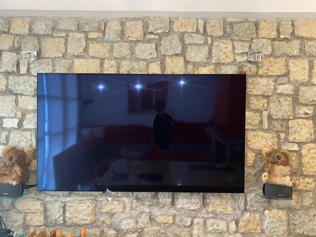 a flat screen tv hanging on a stone wall at Arachova Vip smart chalet-Villa Eva 1 in Arachova