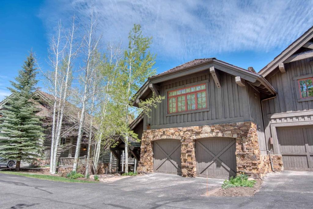 a house with a garage in front of a driveway at Bachelor Gulch Collection by East West Hospitality in Avon