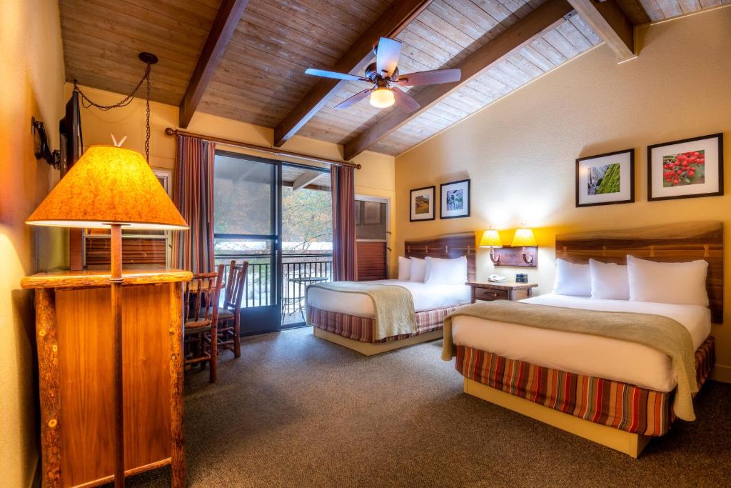 a hotel room with two beds and a balcony at Yosemite Valley Lodge in Yosemite Village