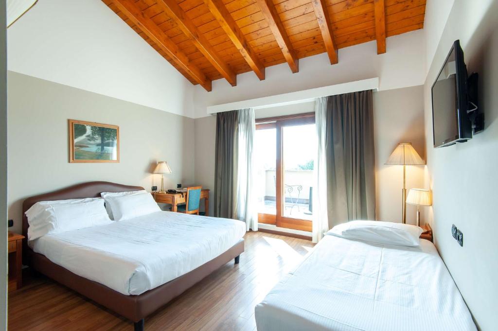 sypialnia z 2 łóżkami i telewizorem z płaskim ekranem w obiekcie Hotel Horizon Wellness & Spa Resort - Best Western Signature Collection w mieście Varese