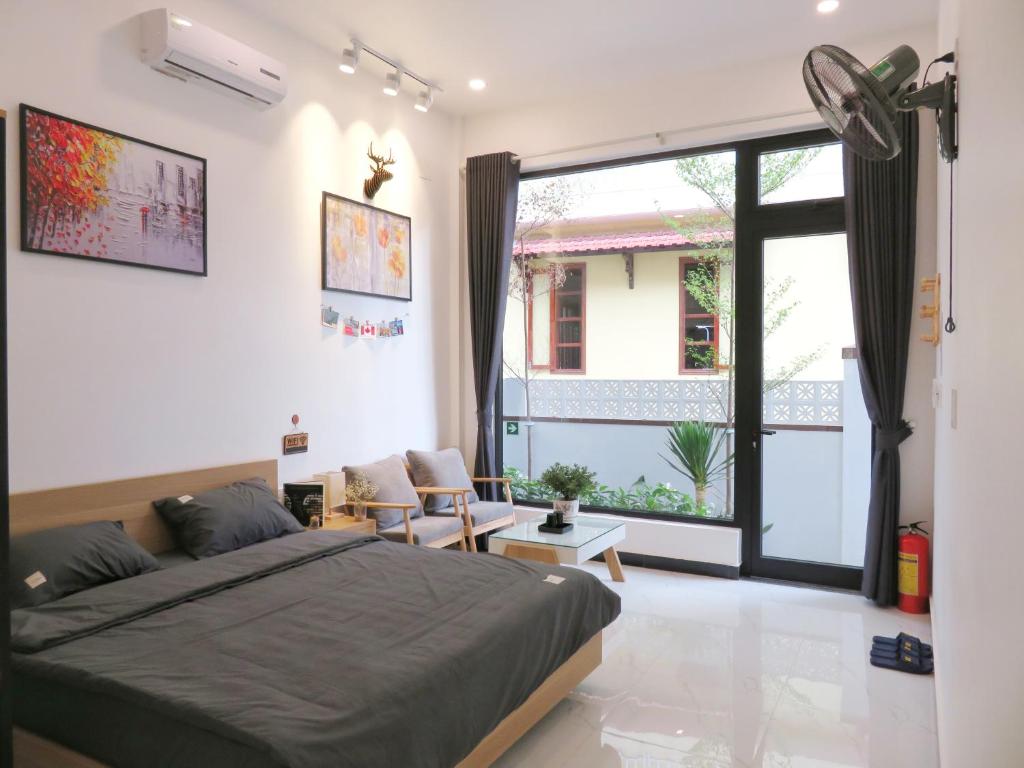 um quarto com uma cama e uma grande janela em Robin House em Hue