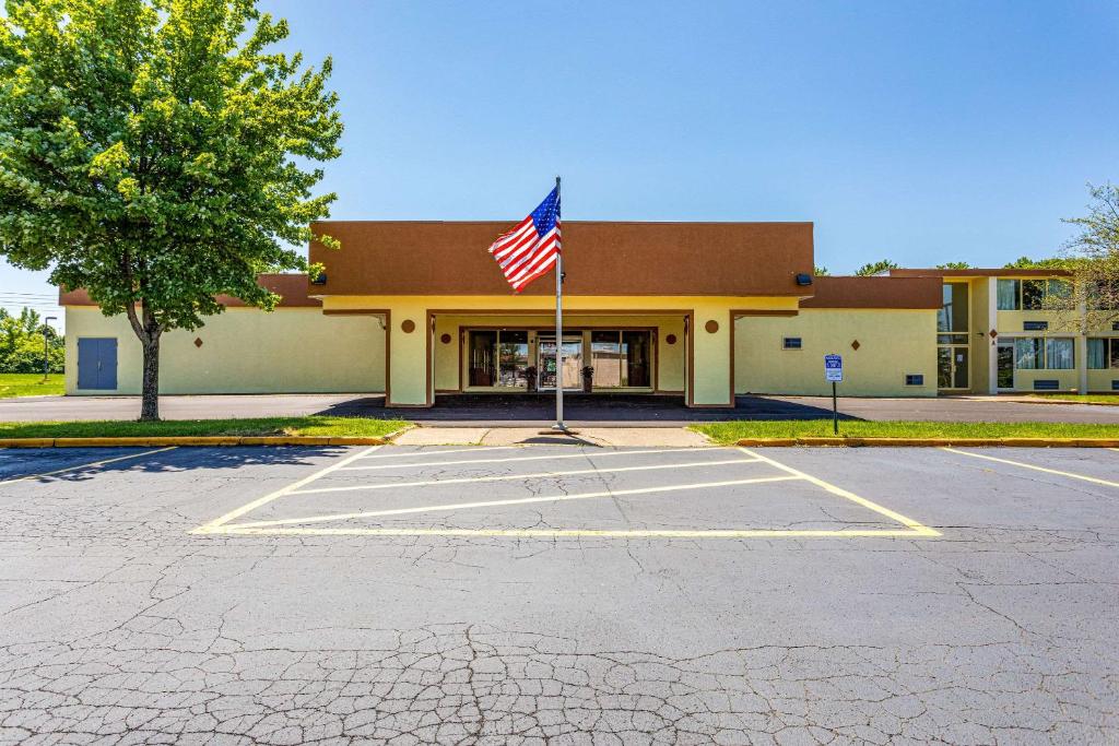 un edificio con una bandera americana en un estacionamiento en Econo Lodge, en Fredonia
