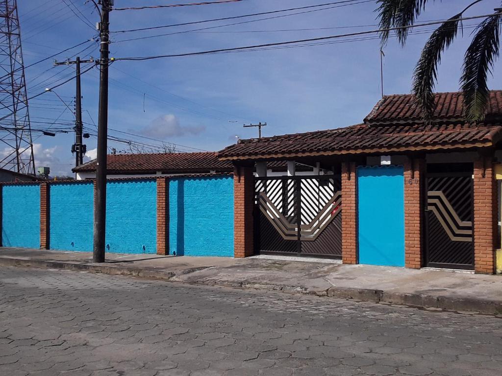 un edificio con porte blu sul lato di una strada di Hostel do Enzo a Itanhaém