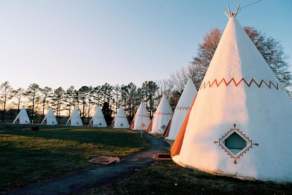 a group of tents in a field with trees at Historic Wigwam Village No 2 in Cave City