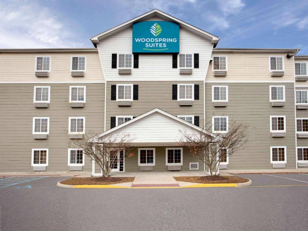 a building with a sign that reads woodworking suites at WoodSpring Suites Atlanta McDonough in McDonough