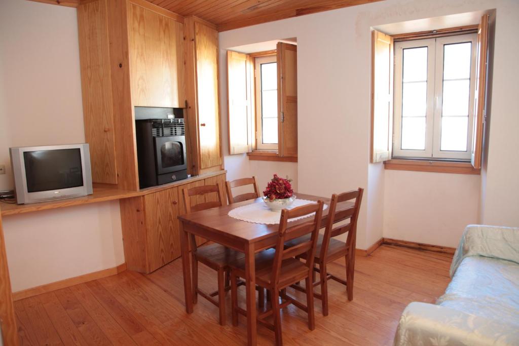 a living room with a table and a tv at Casa das Tias in Manteigas