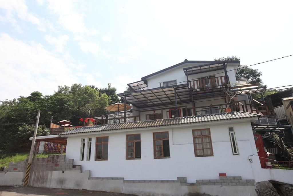 ein weißes Haus mit einer Treppe davor in der Unterkunft Two Dots On Line Homestay in Hualien