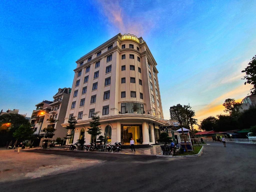 un gran edificio blanco con gente parada frente a él en Lotus Hotel & Apartment, en Hai Phong