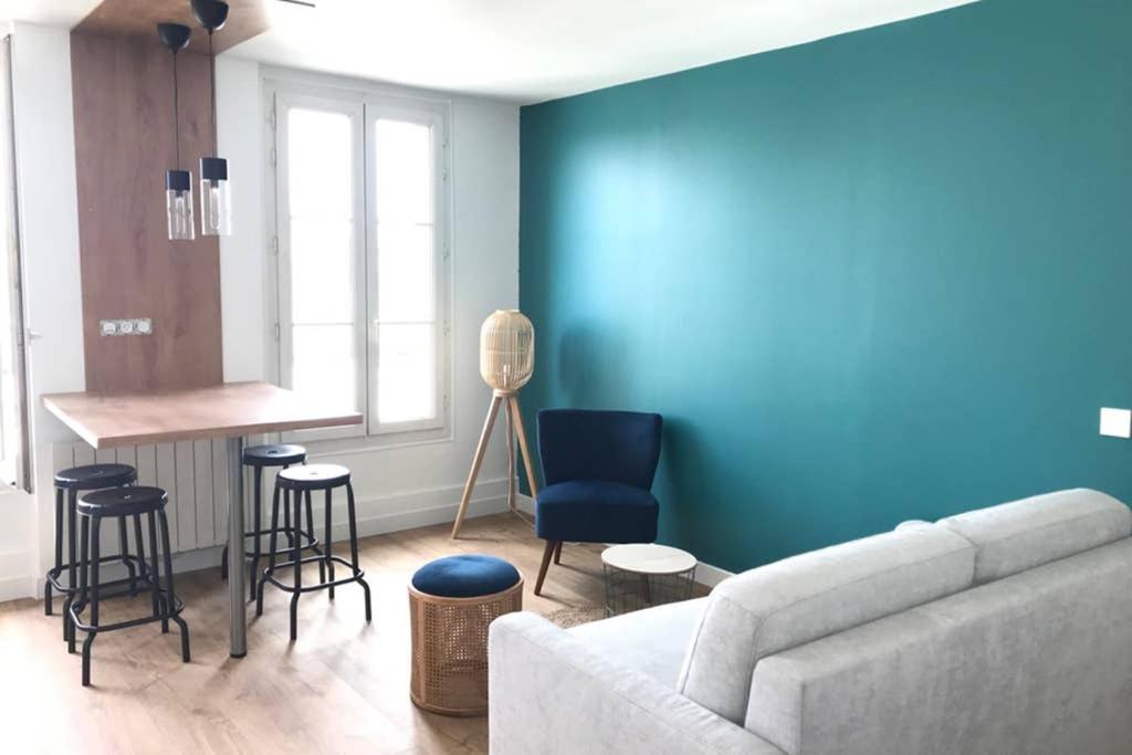 a living room with a couch and a blue wall at le Nicole in Chartres