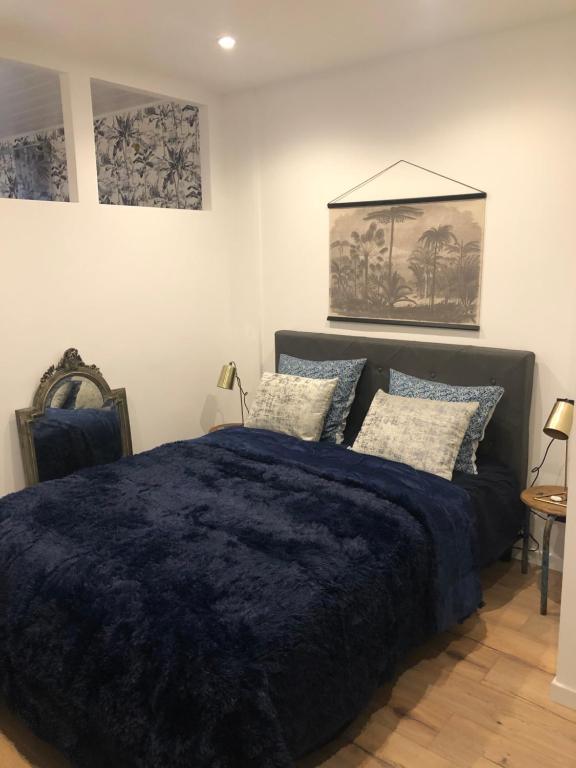 Un dormitorio con una gran cama azul con almohadas en LA MER, en La Grande-Motte