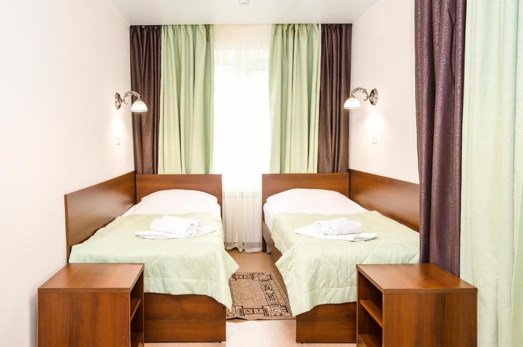 a hotel room with two beds and a window at Planeta Hotel in Chelyabinsk